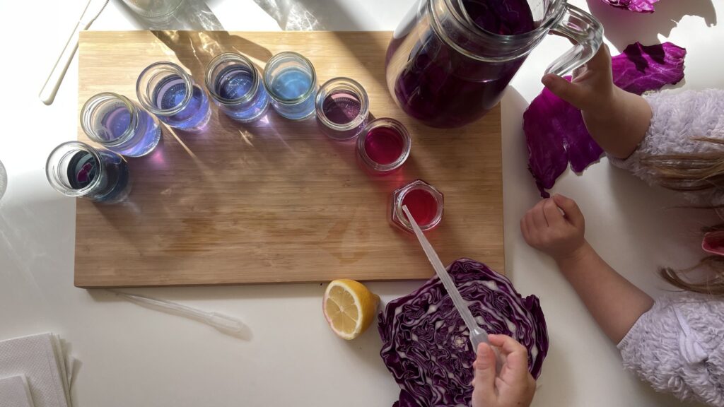 Children mixing colored liquids in glass jars